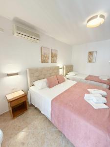 a bedroom with two beds and a table at Jadran Apartments in Rafailovici