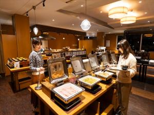 two people standing at a counter in a restaurant at Kyukamura Ibusuki in Ibusuki +148 photos
