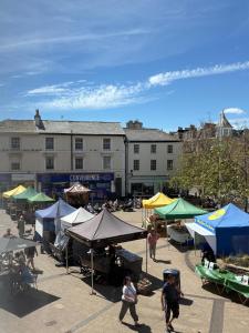 a market with tents and people walking in front of a building at 17 French Street in Teignmouth