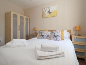 a bedroom with a white bed with towels on it at Church View in Hull
