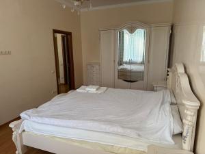 a white bed in a bedroom with a window at Аркадия, Генуэзская in Odesa