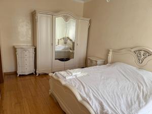 a bedroom with a white bed and a dresser at Аркадия, Генуэзская in Odesa