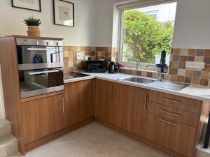 a kitchen with wooden cabinets and a sink and a window at 17 French Street in Teignmouth