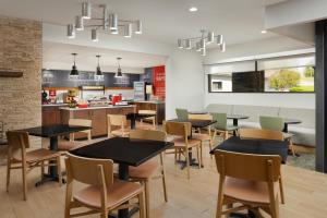 a restaurant with tables and chairs and a kitchen at Hampton Inn Oak Ridge Knoxville in Oak Ridge