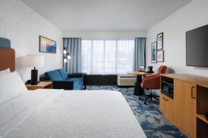 a hotel room with a bed and a living room at Hampton Inn Oak Ridge Knoxville in Oak Ridge +16 photos