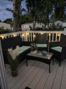 a patio with two chairs and a table on a deck at Coastal Caravan at Seton Sands -Near Edinburgh in Port Seton