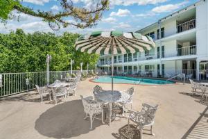 a patio with a table and chairs and an umbrella at Quality Inn Eureka Springs South in Eureka Springs