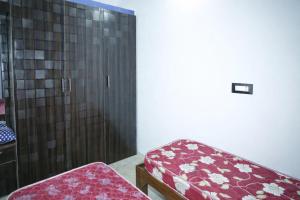 a room with a red bench and a shower at Sindu Homestay in Kalasa