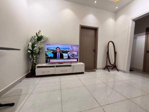 a living room with a flat screen tv on a cabinet at Maatambaba Homes in Tamale