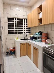 a kitchen with wooden cabinets and a sink at Maatambaba Homes in Tamale