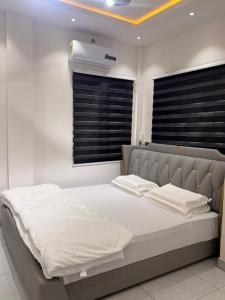 a bedroom with a large bed with white sheets at Maatambaba Homes in Tamale