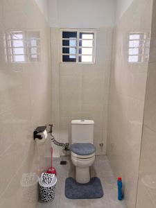a bathroom with a toilet and a window at Maatambaba Homes in Tamale +14 photos