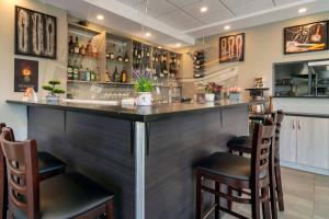eine Bar in einem Restaurant mit zwei Hockern in der Unterkunft Quality Inn in Nanaimo