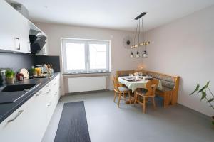 a kitchen with a table and a dining room at Ferienwohnung Hummel in Gammertingen +18 photos