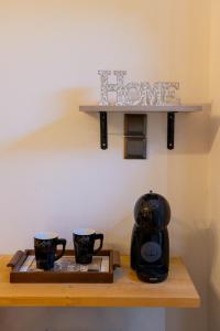 two coffee mugs on a wooden shelf with a coffee maker at family home in Dimitsana