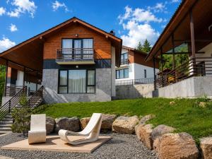 a house with a pair of chairs in front of it at Crown Villa Bakuriani in Bakuriani