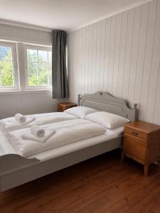 a bedroom with a large white bed and a window at Stryn Panorama in Stryn