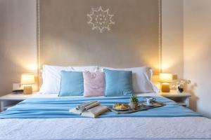 a bed with a tray of food on it at Boutique Hotel Sant'Andrea & Relais in San Pantaleo