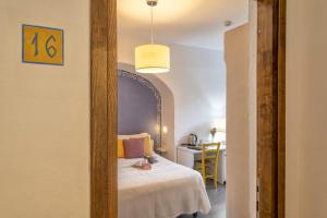 a room with a bed and a table with a desk at Boutique Hotel Sant'Andrea & Relais in San Pantaleo