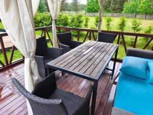 a wooden table and chairs on a deck at River Kemping in Jūrmala