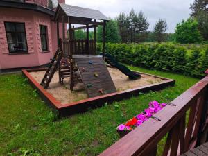 a playground in a yard with a slide and flowers at River Kemping in Jūrmala