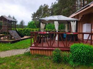 a picnic table with an umbrella in a yard at River Kemping in Jūrmala