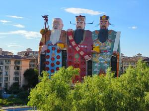 a large statue of three men standing next to each other at 福禄寿酒店 in Beiwusidui