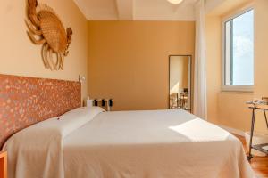 a bedroom with a white bed and a window at Orto al Mare Room Rental in Riomaggiore