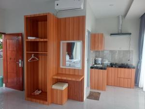 a kitchen with wooden cabinets and a mirror at Lekjon Cottage in Tuktuk Siadong +111 photos