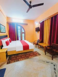 a bedroom with a large bed with colorful curtains at Malti Guest House in Kullu Manali