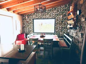 a dining room with a table and a stone wall at Waka Sun Set PICO AZORES in São Roque do Pico