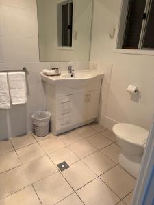 a white bathroom with a sink and a toilet at The Holiday Home Griffith in Griffith +10 photos