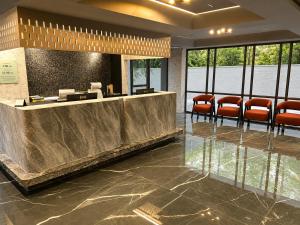 a lobby with a waiting room with orange chairs at Hotel Aston Residency in Kolkata +17 photos