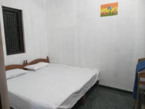 a bedroom with two beds and a picture on the wall at Breezy Villa - Arugambay in Arugam Bay