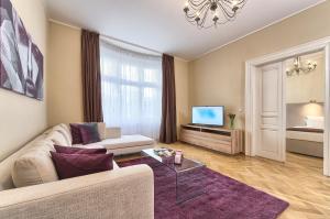 ein Wohnzimmer mit einem Sofa und einem TV in der Unterkunft Maiselova 5 Apartment in Prag