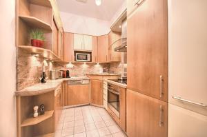 a kitchen with wooden cabinets and a tiled floor at Maiselova 5 Apartment in Prague