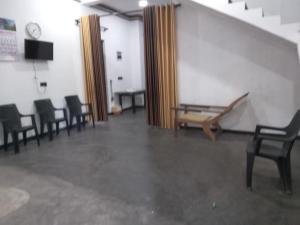 a room with chairs and a table and stairs at Breezy Villa - Arugambay in Arugam Bay