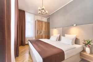 Un dormitorio con una cama grande y una lámpara de araña. en Maiselova 5 Apartment, en Praga