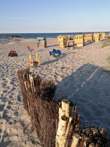 a sandy beach with children playing on the beach at Ferienwohnung Möwe in Schönberg +2 photos