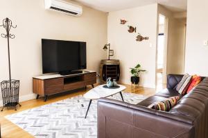 a living room with a couch and a flat screen tv at Rooftops on HenryCentre of West End Cafes in Fremantle