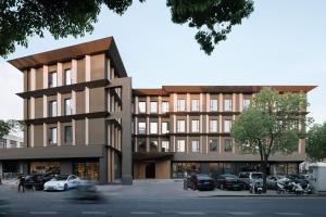 a large building with cars parked in a parking lot at The Yard Boutique Hotel Shanghai 一隅酒店上海虹桥漕河泾店 in Shanghai