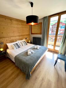 a bedroom with a large bed and a large window at L'Écrin Alpin - Somptueux 4 pièces Centre Station à 100m du Jandri 3S in Les Deux Alpes