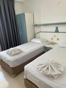 two beds in a hotel room with white sheets at Atlantis Apart in Marmaris