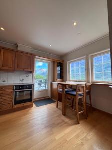 a kitchen with a table and chairs and windows at Stryn Panorama in Stryn
