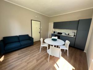 a living room with a blue couch and a table and chairs at Urban Apartments RE in Reggio Emilia +13 photos