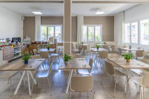 a restaurant with tables and chairs and windows at B&B Hotel Serenità in Bellaria-Igea Marina