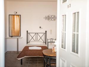 a small bedroom with a bed and a table at Iron House in Agios Georgios