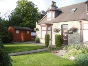 a house with a garden and a shed at Beeches Guest House in Dyce