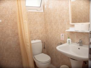 a bathroom with a toilet and a sink at Iron House in Agios Georgios