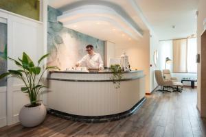 a man standing behind a counter in a room at Hotel Picobello Pineta in Lido di Jesolo +113 photos